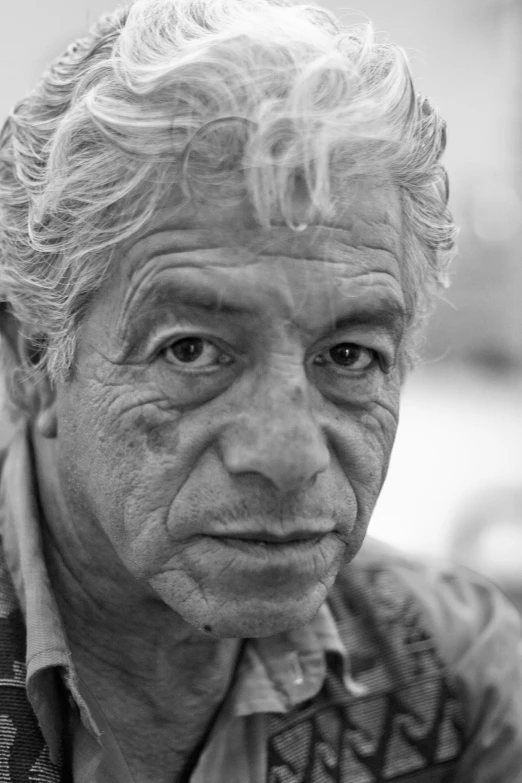 an older man is posing with a cigarette in his mouth