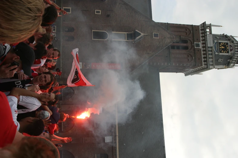 a crowd at a concert with people holding flarers