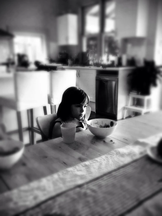 a woman in black and white sitting at a table eating food