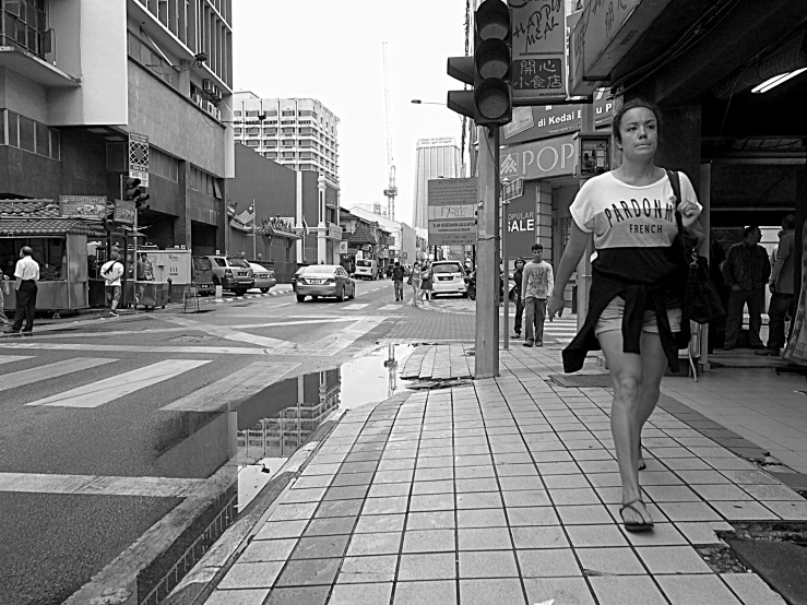 a black and white po of a woman walking down a street