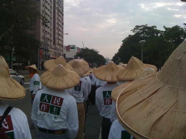 large group of people with hats walking down the street