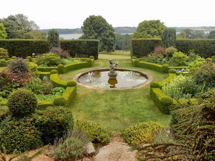 a fountain surrounded by grass in a garden