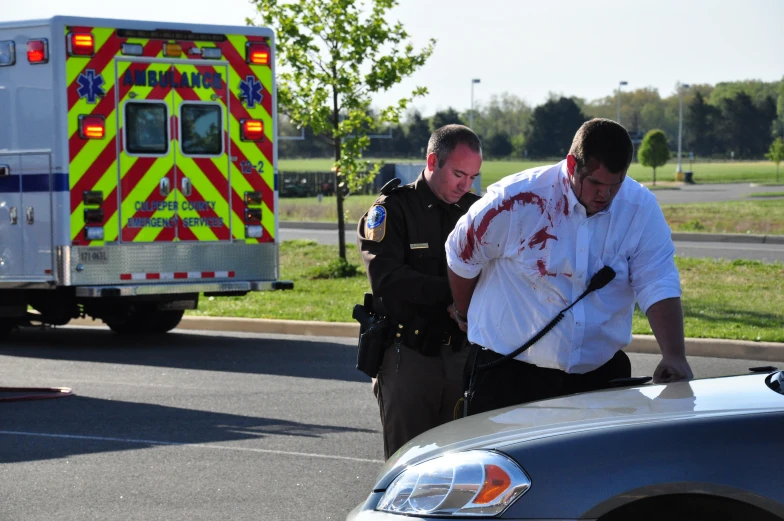 two men look at a  covered police officer