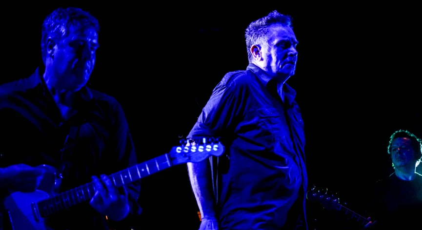 a man playing an electric guitar at a concert