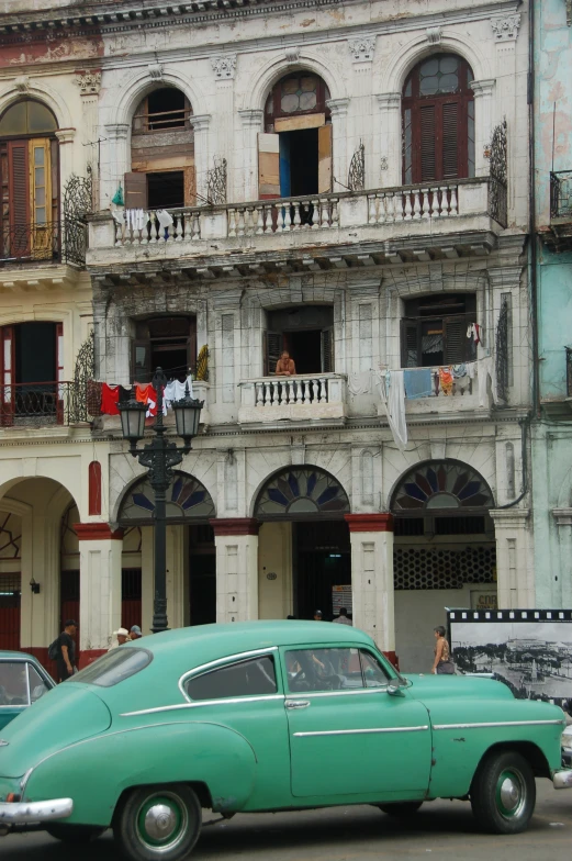 an old fashioned car parked in front of a building