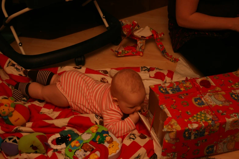 a baby lays down playing with toys