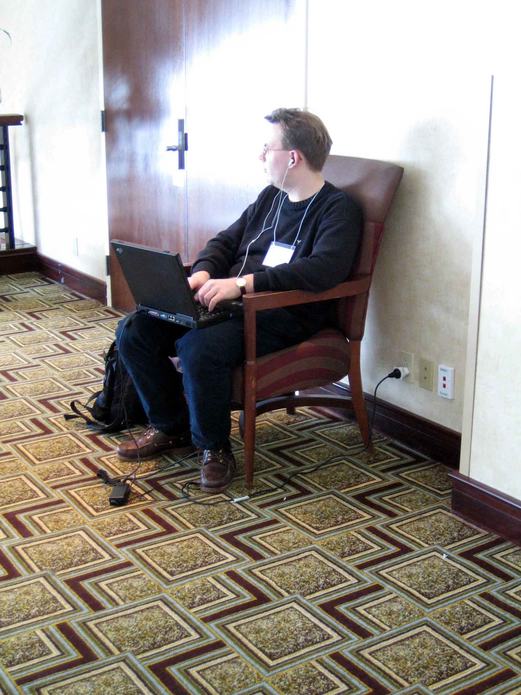 a man that is sitting on a chair with a laptop