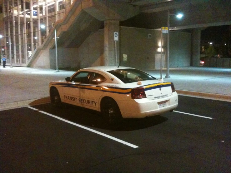 a parked white police car sitting in the middle of a parking lot