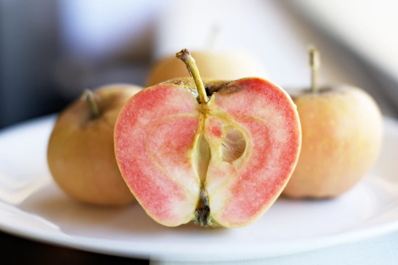 a close up of two apples sitting on top of a white plate