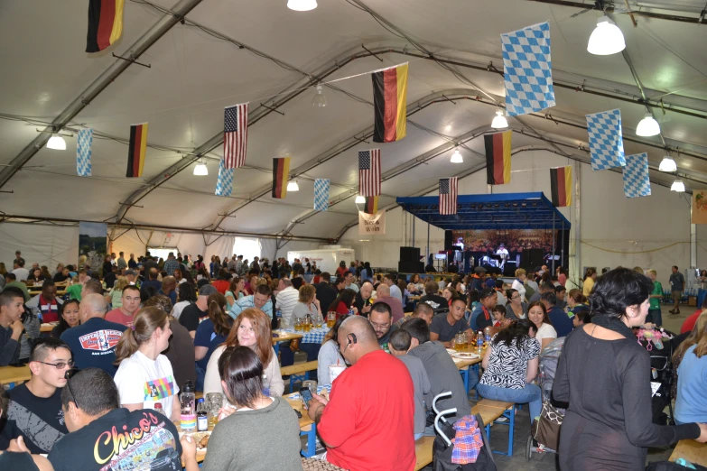 people sitting at tables with flags hanging from the ceiling