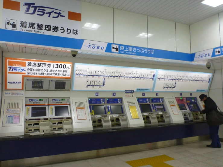 a woman waiting at an atm machine in japan