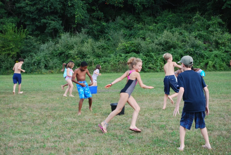 s are running across a field, with one child holding a bottle