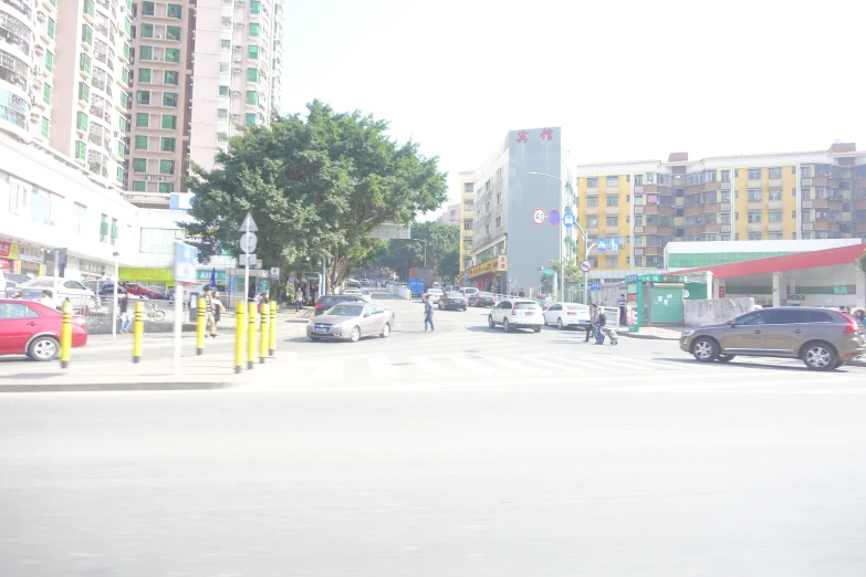 cars and people are on a street in a city