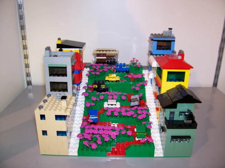 a toy model city has flowers and buildings surrounding it