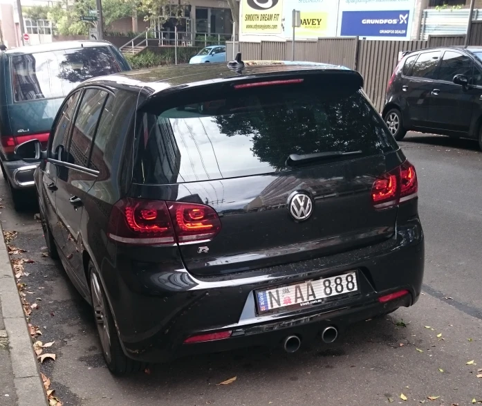 three cars are parked next to the sidewalk