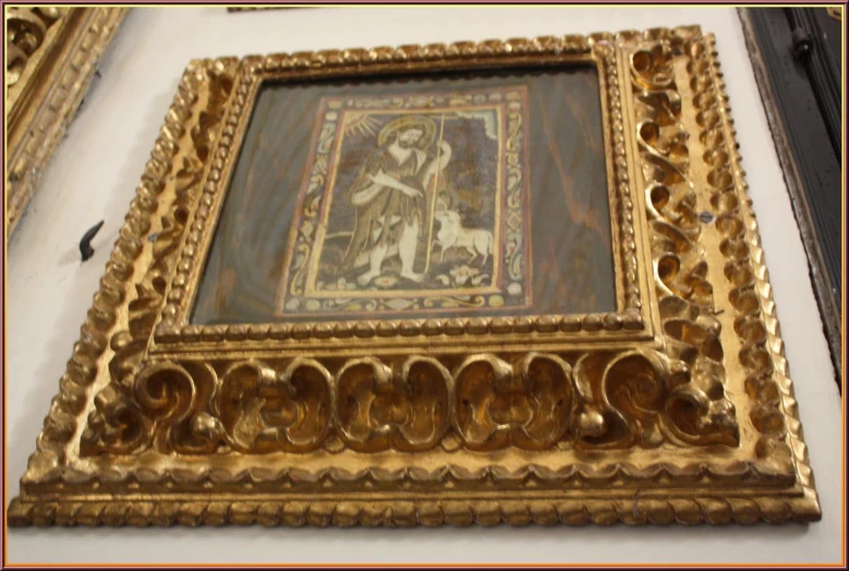 an ornate gold frame holds a painting of a lady with a deer