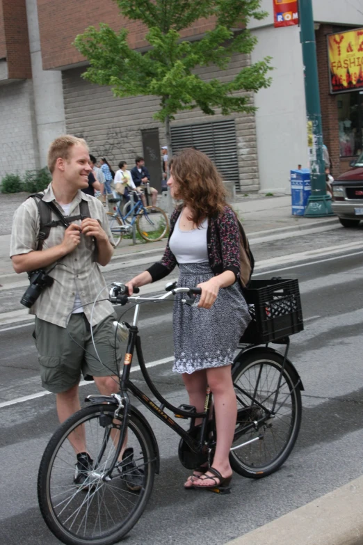 two people on bikes talking in a street