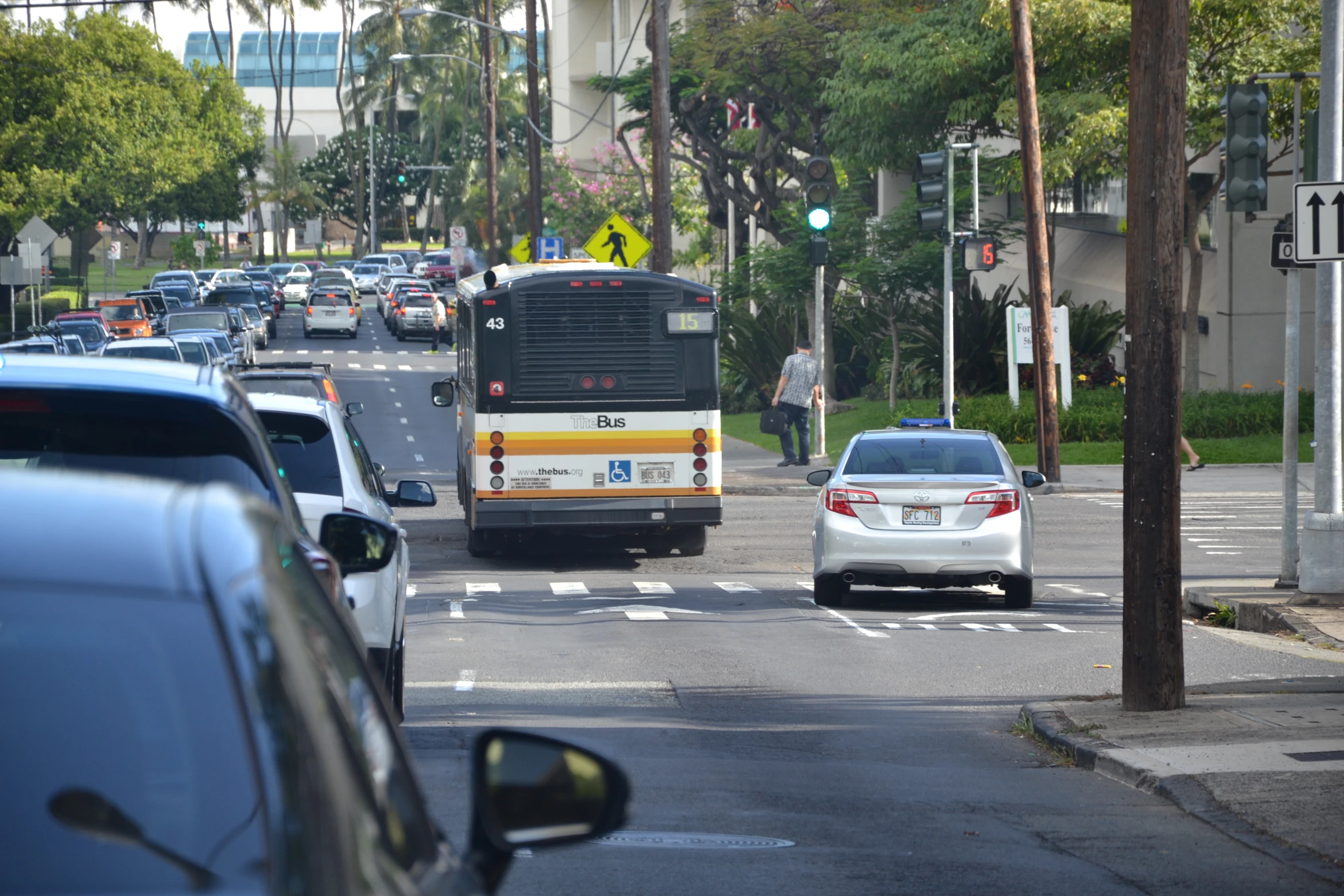 a busy road with cars and buses, near tall buildings