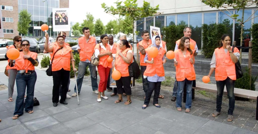 some people wearing orange shirts standing on some steps