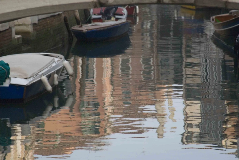 several boats are moored in an open canal