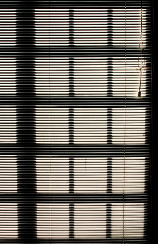 the top of a window in a building, that has light streams in it