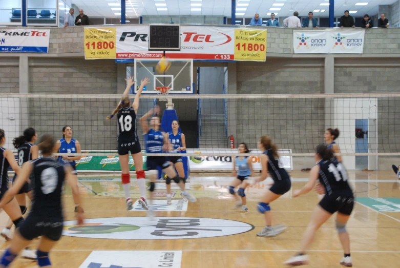 a group of young women playing basketball in a gym