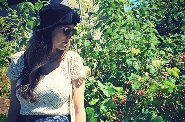 a young woman holding an umbrella next to plants