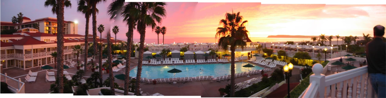 palm trees are around a swimming pool in a resort