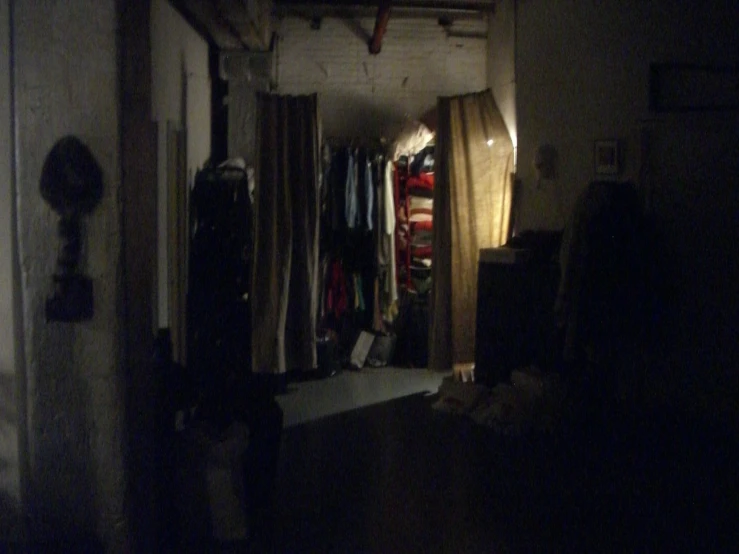 an unmade closet is shown with hanging clothes