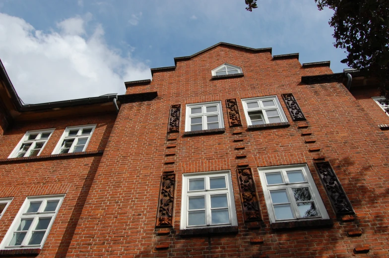 an old building has many windows and a tree in front