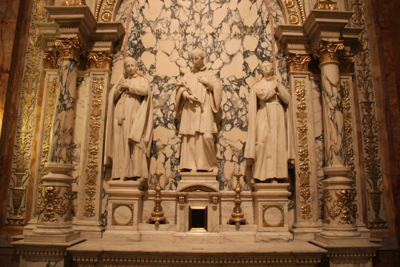 statues of three men and women stand in a church