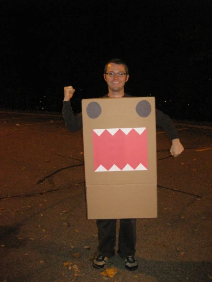 a person holding up a cardboard box shaped like a mouth and teeth