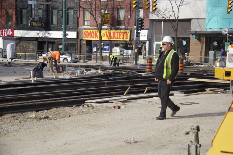 there is a construction worker walking by train tracks