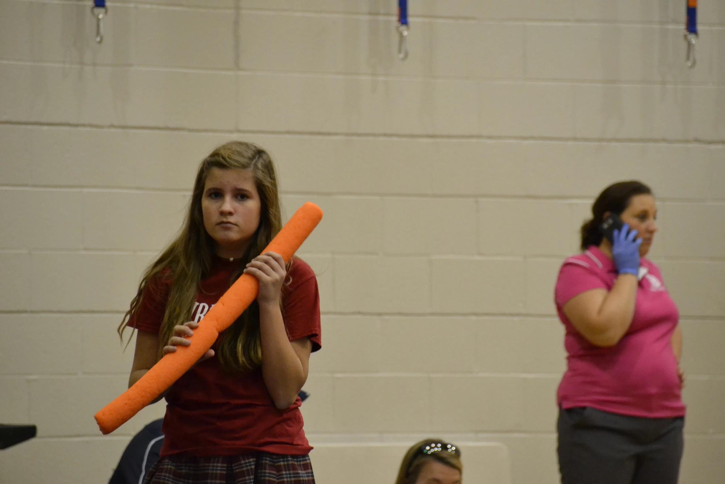 three girls holding up baseball bats on a court