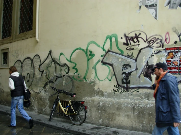 a man on his cellphone near the street and graffiti