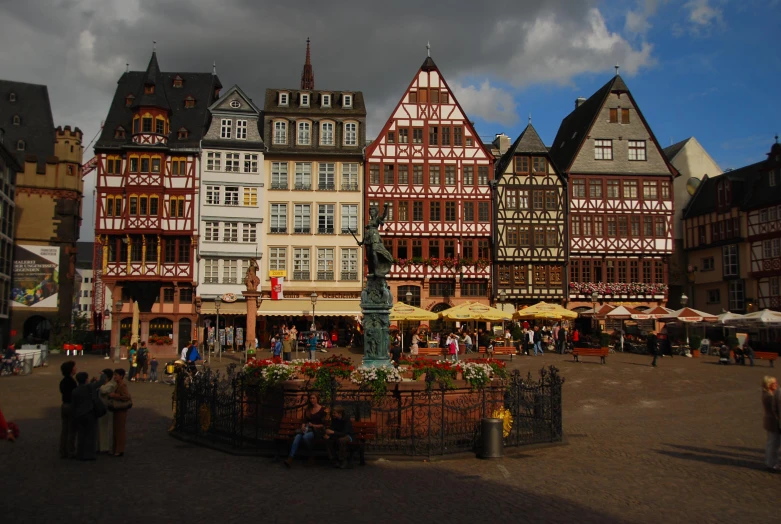 an old european market is displayed in front of other historical buildings