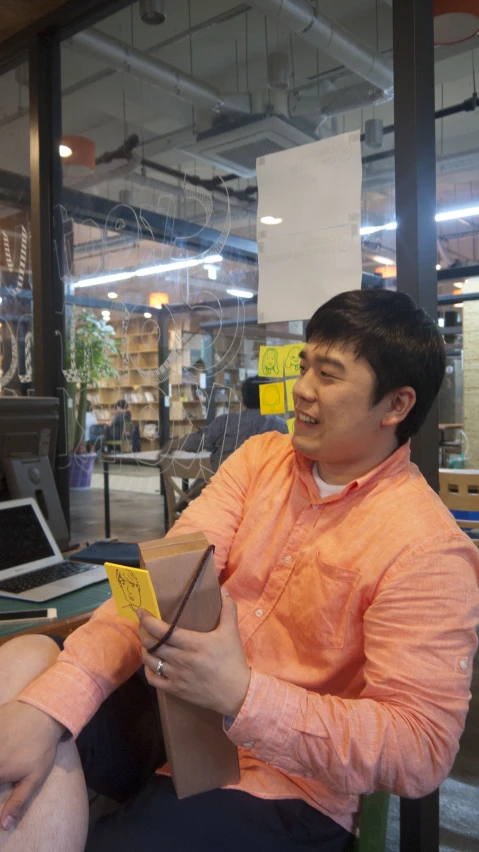 man sitting down in a box looking at the box he's holding