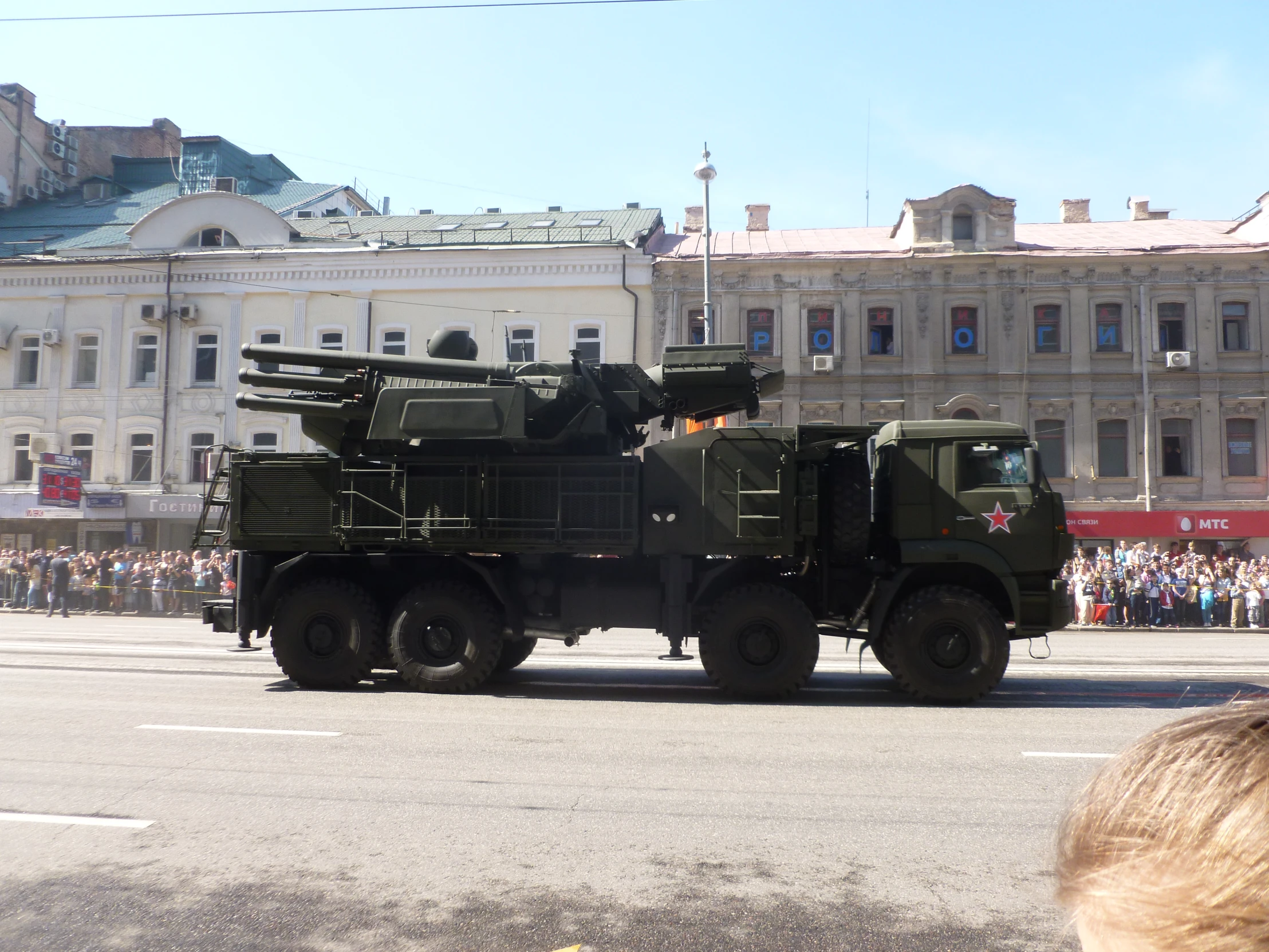 several soldiers riding on top of army trucks