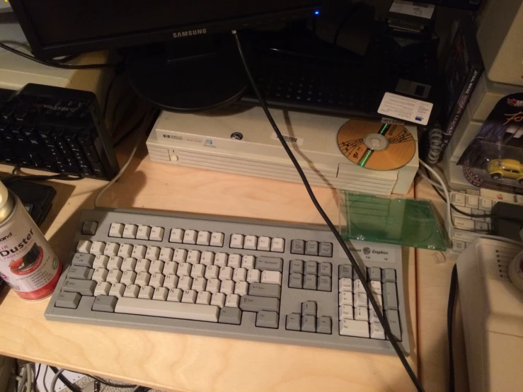 a desk with an older computer and keyboard sitting on top of it