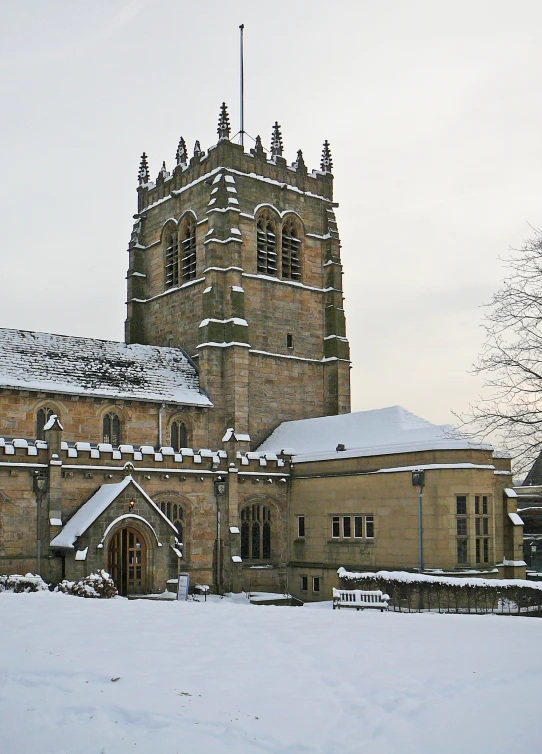 an old church with snow on the roof and buildings