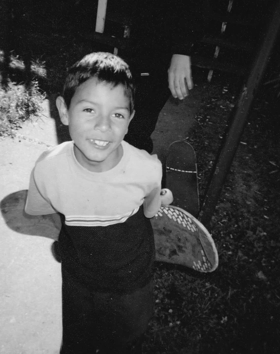 a boy holds his frisbee while walking past a man