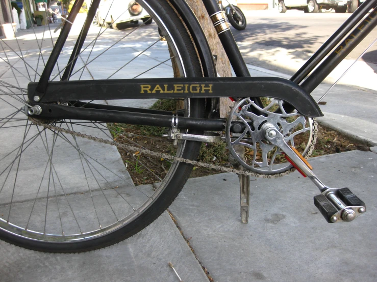 there is a black bicycle parked at the curb