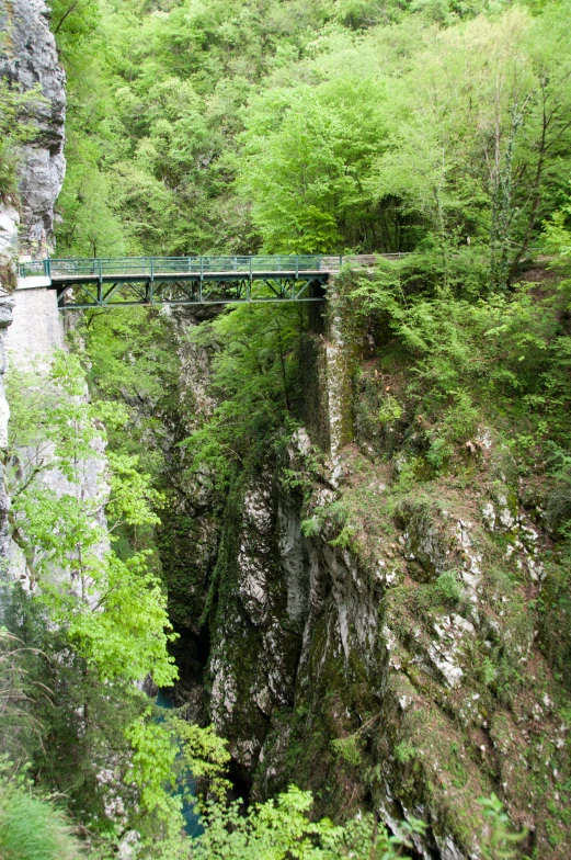 a bridge that is crossing over a very narrow mountain side