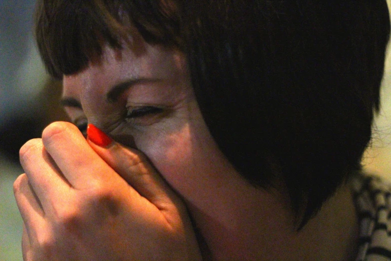 a woman is touching her face with her hand