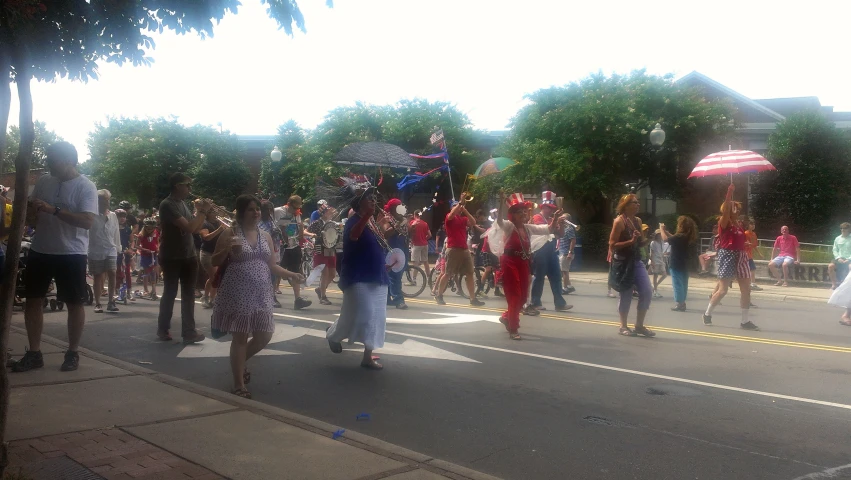 the crowd of people is walking down the street