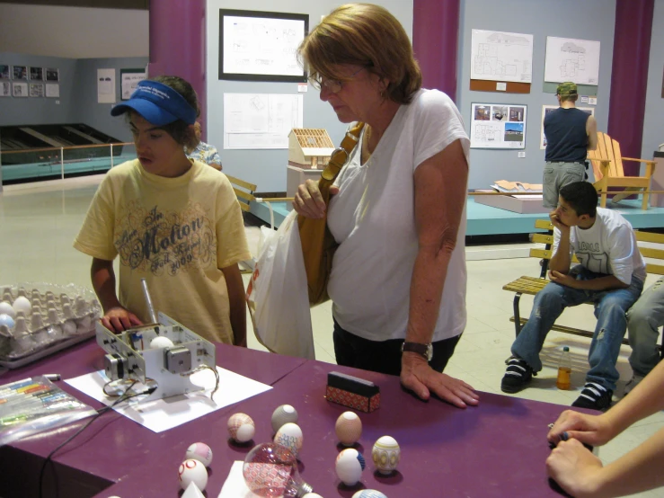 two women and children at an exhibit of eggs