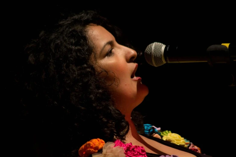 an attractive woman singing into a microphone