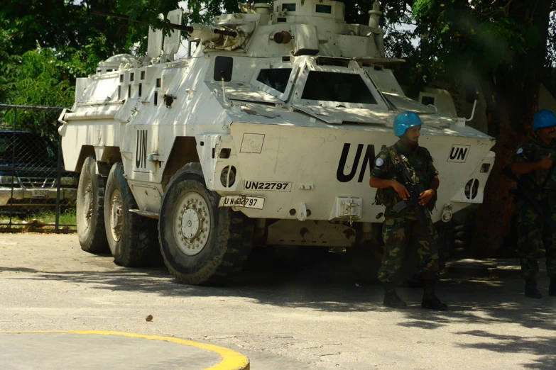 the soldiers are looking at the military vehicle