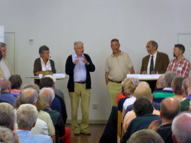 men and women in a meeting room standing around a table