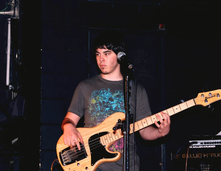 a man playing a music instrument with a microphone in the background